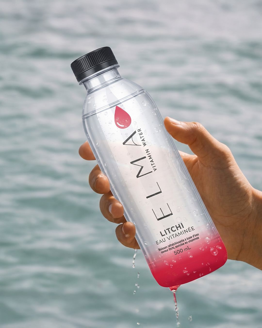 ELMA Vitamin Water Litschi-Flasche vor dem Meer